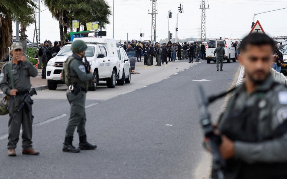 Israeli officials work at the scene of what Israel's police describe as a suspected shooting attack