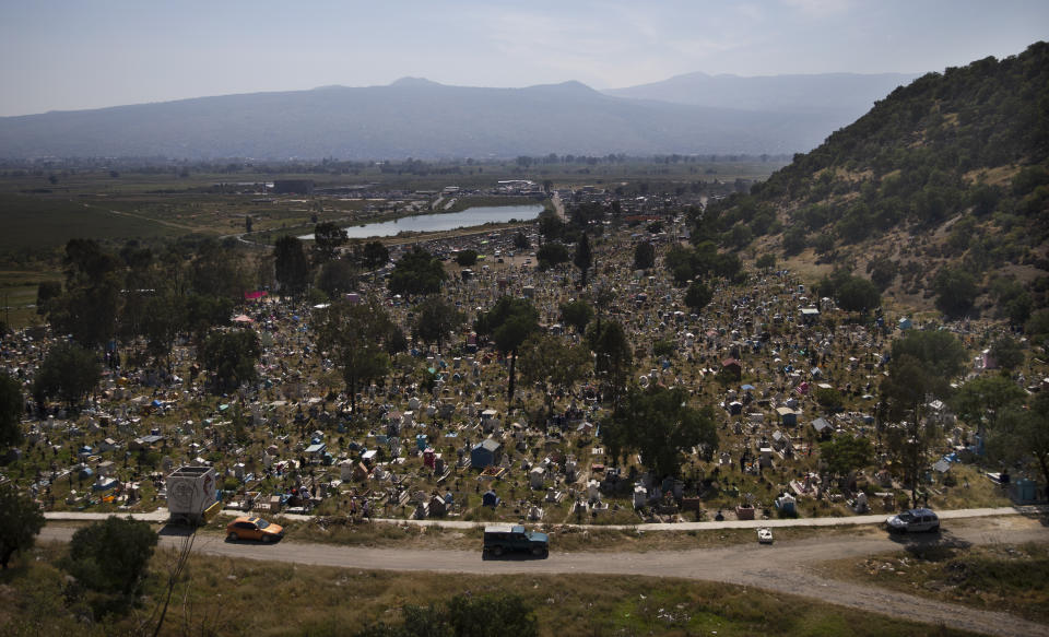 Graves are decorated with crosses and grass in a section of the municipal cemetery Valle de Chalco amid the new coronavirus pandemic, on the outskirts of Mexico City, Sunday, Oct. 25, 2020. Mexican families traditionally flock to local cemeteries to honor their dead relatives as part of the "Dia de los Muertos," or Day of the Dead celebrations, but according to authorities the cemeteries will be closed this year to help curb the spread of COVID-19. (AP Photo/Marco Ugarte)