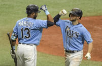 Tampa Bay Rays' Manuel Margot, left, greets Brandon Lowe, right, after Lowe's solo home run during the sixth inning of a baseball game Sunday, May 16, 2021, in St. Petersburg, Fla. (AP Photo/Steve Nesius)