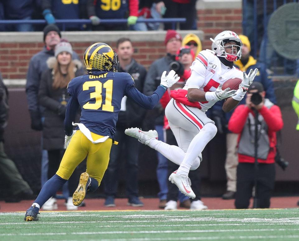 Ohio State receiver Garrett Wilson catches a long pass against Michigan defensive back Vincent Gray during the first half Saturday, Nov. 30, 2019, at Michigan Stadium.