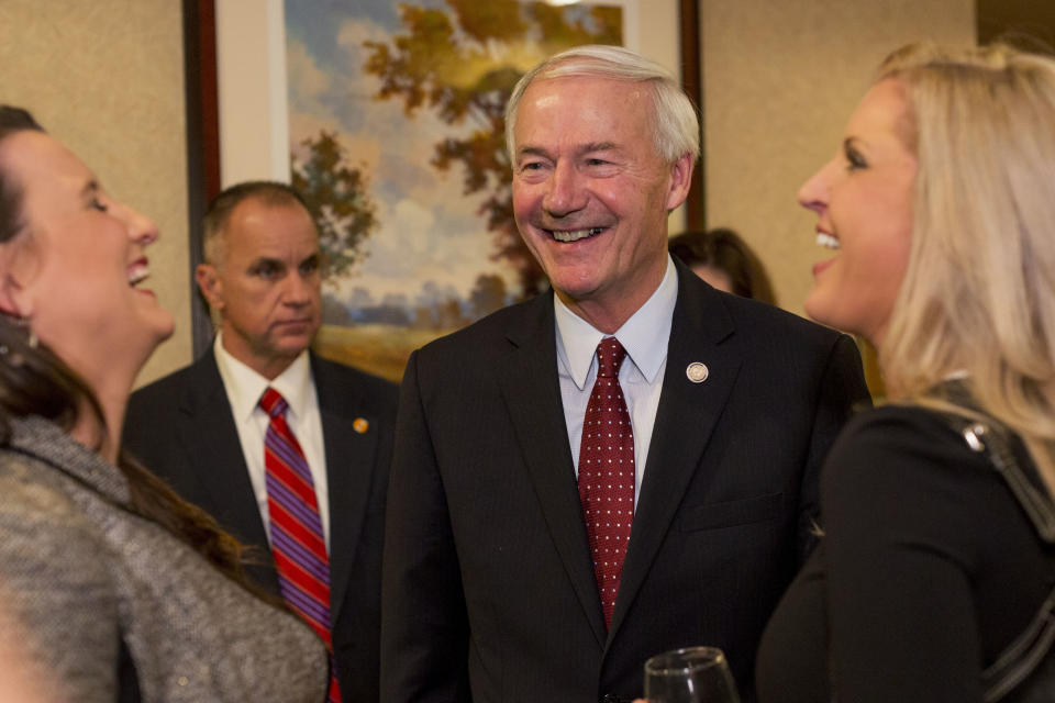 Gov. Asa Hutchinson talks to supporters Susanna Watt, left, and Kristi McKinnon, right, at his election night rally Tuesday, Nov. 6, 2018, in Little Rock, Ark. (AP Photo/Gareth Patterson)