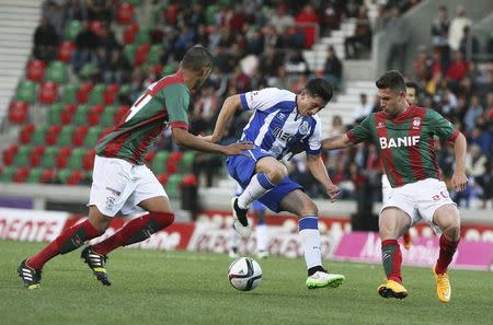 Porto's Hector Herrera (C) fights for the ball with Maritimo's Raul Silva (L) and Bruno Gallo during their Portuguese premier league soccer match at Barreiros stadium in Funchal January 25, 2015. REUTERS/Duarte Sa