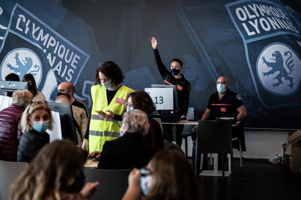 Firefighters welcome people to be vaccinated against Covid-19 on the opening day of a mass vaccination centre set up in the Olympique Lyonnais soccer Stadium, in Decines-Charpieu, Saturday, April 3, 2021. (Jean-Philippe Ksiazek, Pool via AP)