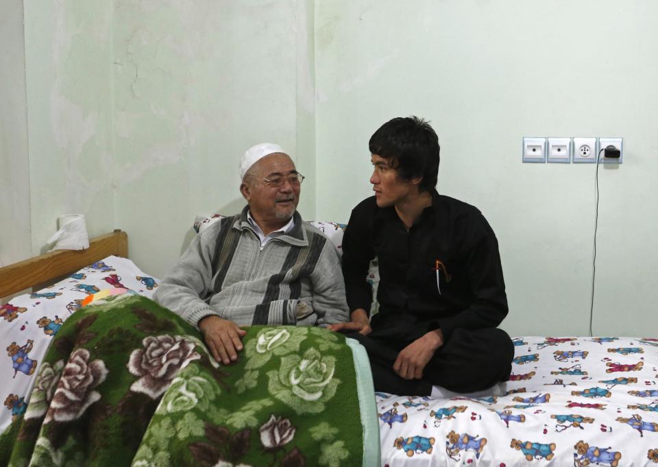 Abbas Alizada, who calls himself the Afghan Bruce Lee, talks to his father at their house in Kabul