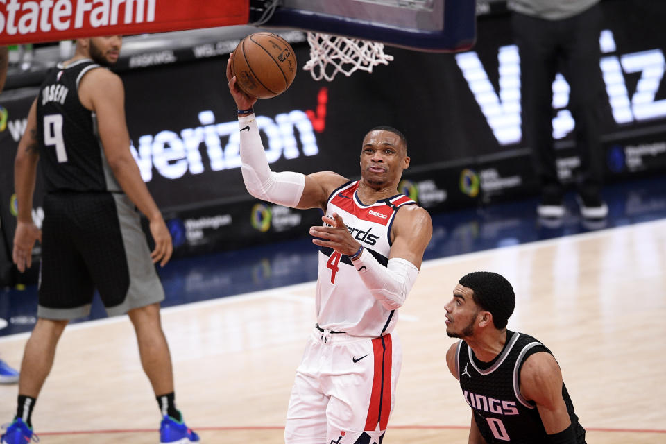 Washington Wizards guard Russell Westbrook (4) goes to the basket past Sacramento Kings guard Justin James, right, during the first half of an NBA basketball game, Wednesday, March 17, 2021, in Washington. (AP Photo/Nick Wass)