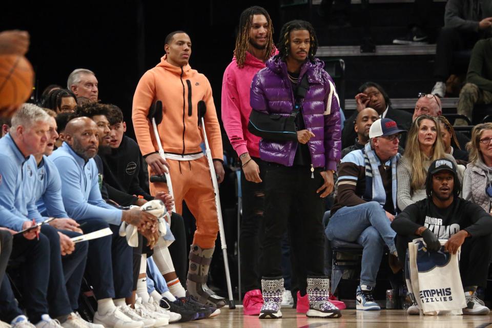 Jan 15, 2024; Memphis, Tennessee, USA; Memphis Grizzlies guard Desmond Bane (22), forward Brandon Clarke (15) and guard Ja Morant (12) watch from the bench during the first half against the Golden State Warriors at FedExForum. Mandatory Credit: Petre Thomas-USA TODAY Sports