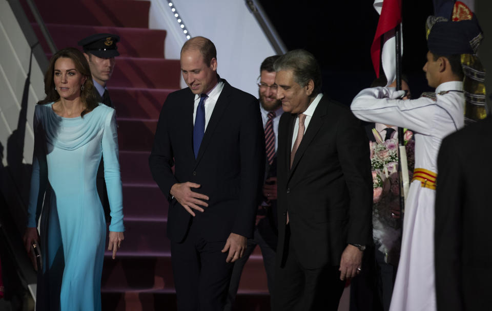 Pakistani Foreign Minister Shah Mahmood Qureshi, right, escorts Britain's Prince William and his wife Kate as they arrive at the Nur Khan base in Islamabad, Pakistan, Monday, Oct. 14, 2019. They are on a five-day visit, which authorities say will help further improve relations between the two countries. (AP Photo/B.K. Bangash)