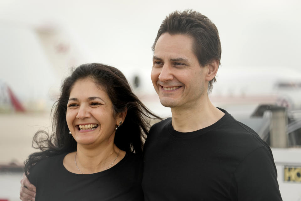 Michael Kovrig embraces his wife Vina Nadjibulla, left, after arriving at Pearson International Airport in Toronto, Saturday, Sept. 25, 2021. China, the U.S. and Canada completed a high-stakes prisoner swap Saturday with joyous homecomings for Kovrig and Michael Spavor, two Canadians held by China and for an executive of Chinese global communications giant Huawei Technologies charged with fraud. (Frank Gunn/The Canadian Press via AP)