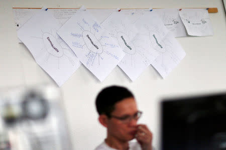 A migrant attends a lesson at the "institute for intercultural communication" in Berlin, Germany, April 19, 2016. Sign reads "Demokratie" (democracy). REUTERS/Hannibal Hanschke