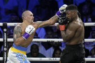 Britain's Anthony Joshua, right, takes a blow from Ukraine's Oleksandr Usyk during their world heavyweight title fight at King Abdullah Sports City in Jeddah, Saudi Arabia, Sunday, Aug. 21, 2022. (AP Photo/Hassan Ammar)