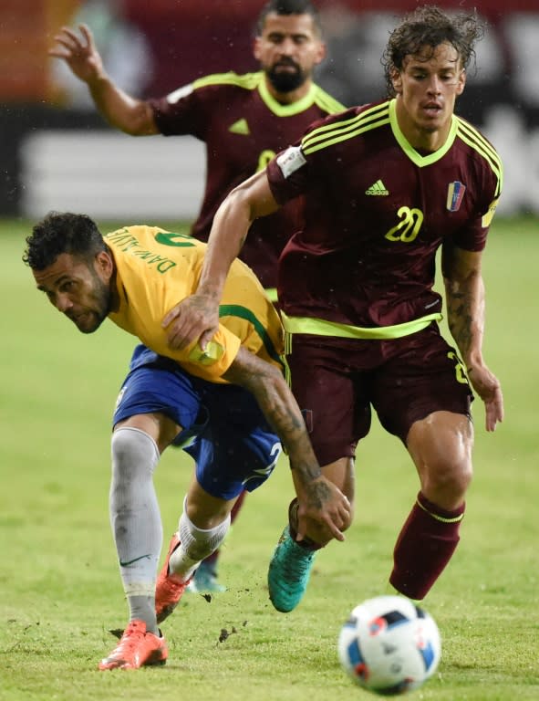 Brazil's Daniel Alves (L) fights for the ball with Venezuela's Rolf Feltscher during their Russia 2018 World Cup qualifier match in Merida, in October 2016