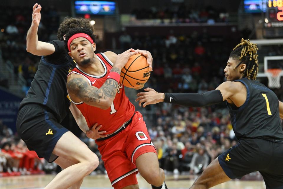 Dec 30, 2023; Cleveland, Ohio, USA; Ohio State Buckeyes guard Roddy Gayle Jr. (1) drives to the basket between West Virginia Mountaineers forward Ofri Naveh (9) and guard Noah Farrakhan (1) during the first half at Rocket Mortgage FieldHouse. Mandatory Credit: Ken Blaze-USA TODAY Sports