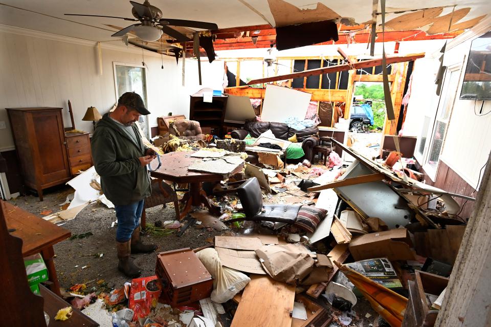Ryan Whitten holds a dog collar that belonged to Dash, one of his three dogs, while walking around in his destroyed home Thursday, May 9, 2024, in Columbia, Tenn. Severe weather and tornadoes caused damage in Tennessee on Wednesday.