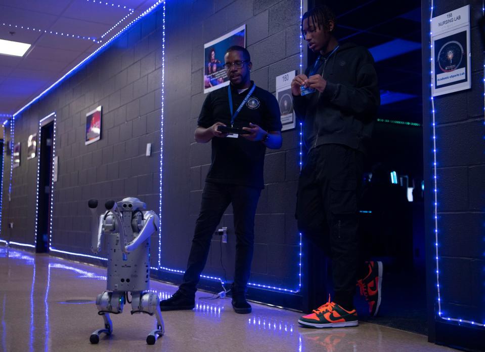 Marcus Horton and Alonzo Rhodes interact with Blue, an AI robotic dog, a a mascot for the Global SMART Technology Innovation Center Tennessee State University at the Avon Williams Campus in Nashville, Tenn., Thursday, Oct. 19, 2023.