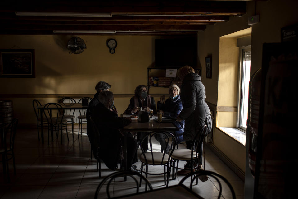 Catholic parishioners sit together in the village bar after Sunday Mass in Riego del Camino, in the Zamora province of Spain, on Sunday, Nov. 28, 2021. (AP Photo/Manu Brabo)