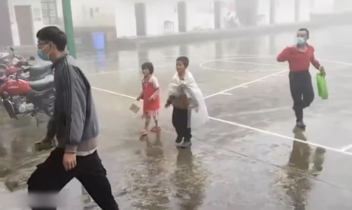 大陸一對小兄妹為了一次免費核酸檢測，大雨中徒步走20公里，連一把傘都沒有。（圖／翻攝自搜狐千里眼微博）