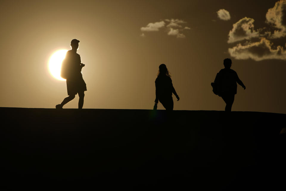 FILE - People walk along a trail as the sun sets, July 16, 2023, in Death Valley National Park, Calif. European climate monitoring organization made it official: July 2023 was Earth's hottest month on record by a wide margin. (AP Photo/John Locher, File)