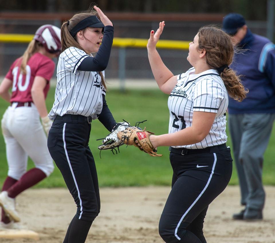 Bellingham High School softball shortstop Ainsley MacNeil, left, high fives Trisla Corshia after tagging out a Millis runner trying to steal second base, April 10, 2024.