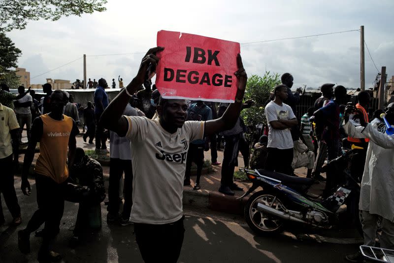 A protester holds a sign during a protest after President Ibrahim Boubacar Keita concessions rejected concessions, aimed at resolving a months-long political stand-off, in Bamako,