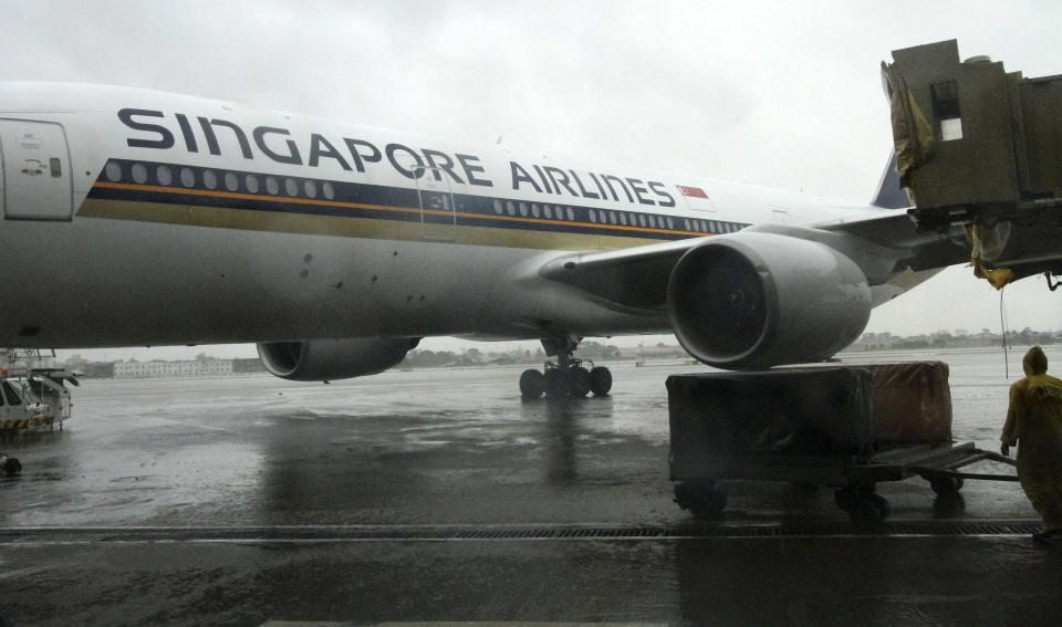 The left wing of a Singapore Airlines passenger plane touches an aerobridge at the Ninoy Aquino International Airport at the onslaught of Typhoon Rammasun, in Paranaque