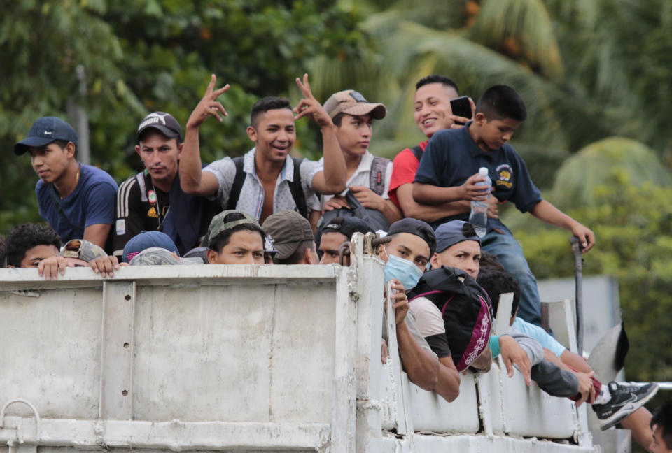 Migrants get a free ride from a trucker toward the Guatemalan border after leaving San Pedro Sula, Honduras, Thursday, Oct. 1, 2020. Hundreds of migrants are testing a well-trod migration route now in times of the new coronavirus. (AP Photo)