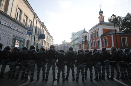 Law enforcement officers stand guard after a rally to demand authorities allow opposition candidates to run in a local election in Moscow