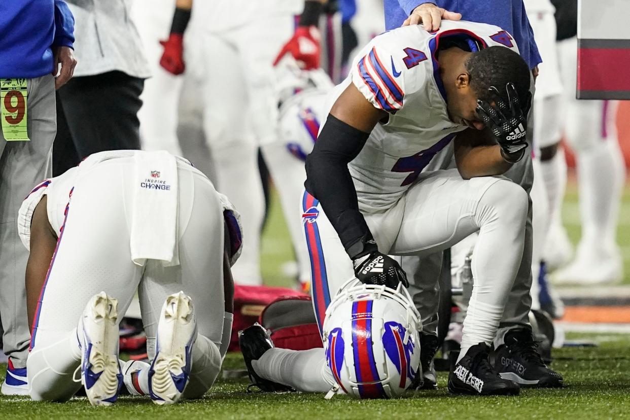 Buffalo Bills players and staff pray for Buffalo Bills' Damar Hamlin during the first half of an NFL football game against the Cincinnati Bengals on Jan. 2, 2023, in Cincinnati.