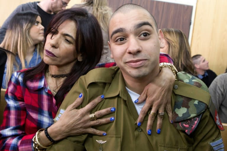 Israeli soldier Elor Azaria is embraced by his mother Oshra at the start of a hearing in a military court in Tel Aviv on February 21, 2017 at which he was sentenced to 18 months in prison for shooting dead a wounded Palestinian assailant