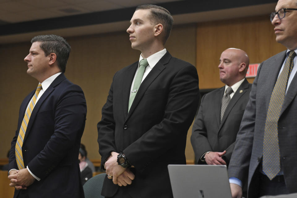 State Trooper Brian North, center, stands in Connecticut Superior Court at the start of the third day of jury deliberations for his trial in Milford, Conn., Friday, March 15, 2024. North was acquitted of all charges Friday in the death of Mubarak Soulemane, a community college student with mental illness who was shot as he sat behind the wheel of a stolen car holding a kitchen knife. (Ned Gerard/Hearst Connecticut Media via AP, Pool)