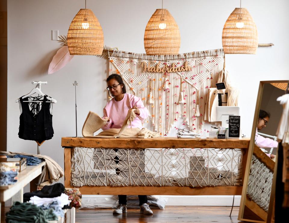 Gianna Anderson of Worcester folds clothes at Haberdash at Crompton Place.