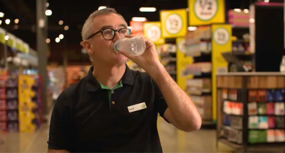 Woolworths CEO Brad Banducci drinking water during an ABC interview.