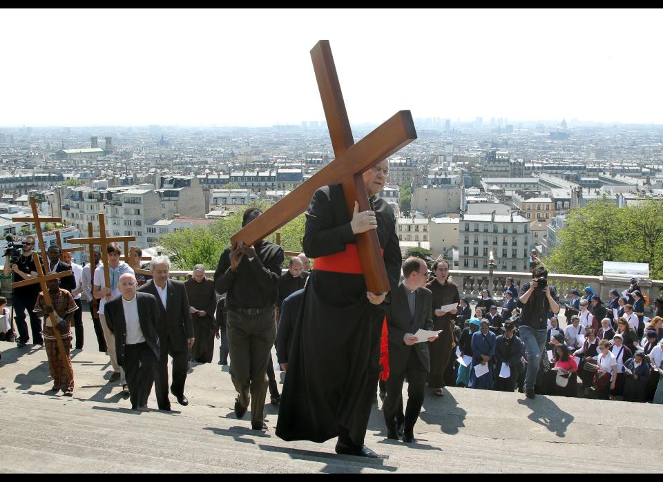 French bishop Andre Vingt-Trois carries a wooden cross to the Montmartre Basilica during a Good Friday procession to commemorate the death of Christ.&nbsp;