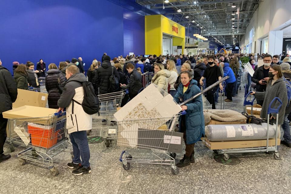 FILE - People wait in a line to pay for purchases at the IKEA store on the outskirts of Moscow, Russia, on March 3, 2022. Russians are snapping up Western fashion and furniture this week as H&M and IKEA sell off the last of their inventory in Russia, moving forward with their exit from the country after it sent troops into Ukraine. Sweden-based H&M and Netherlands-based IKEA had paused sales in Russia after the military operation began and are now looking to unload their stocks of clothing and furnishings as they wind down operations there.. (AP Photo, File)