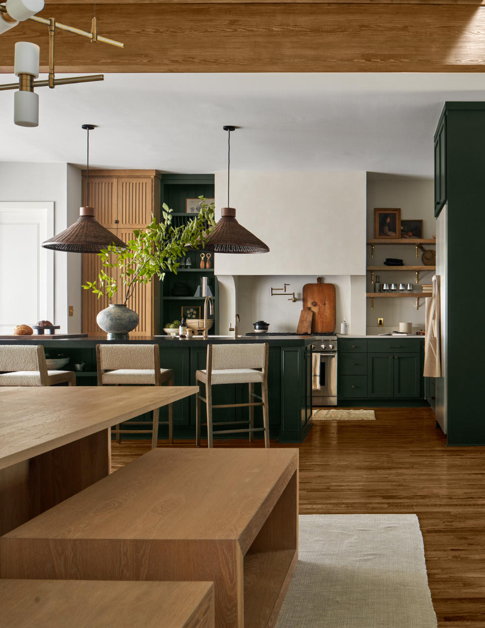 A kitchen with cabinetry painted in a deep forest green shade