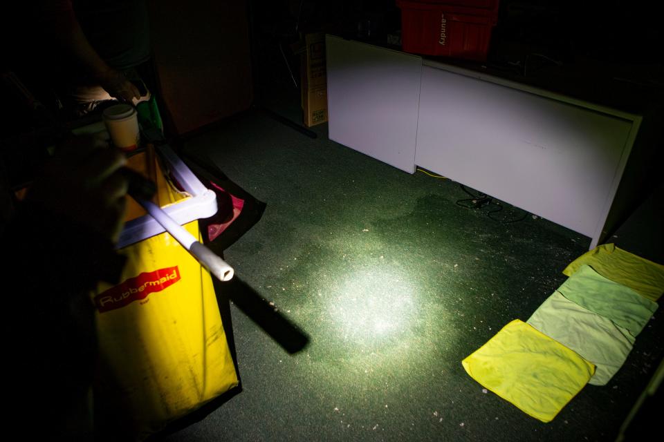 Water stained carpet is illuminated under a flashlight at Agnes Steward Middle School as winter storm recovery gets underway Jan. 18 in Springfield.