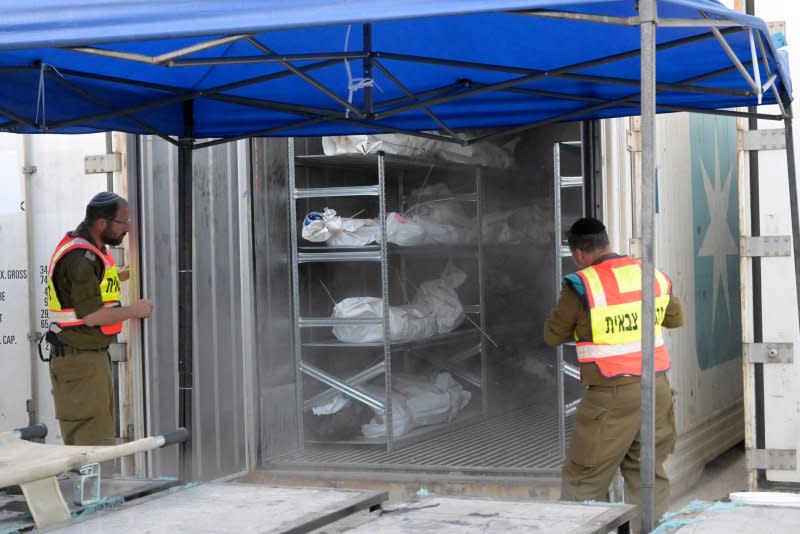 Soldiers from the military rabbinate unit open containers full of bodies and body parts of people slain in the Hamas attack on Israel at the military morgue on the Shura Army Base near Ramla on Tuesday. Photo by Debbie Hill/UPI