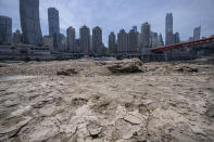 Cracks in dried mud are seen on a portion of the dry riverbed of the Jialing River in southwestern China's Chongqing Municipality, Friday, Aug. 19, 2022. Ships crept down the middle of the Yangtze on Friday after the driest summer in six decades left one of the mightiest rivers shrunk to barely half its normal width and set off a scramble to contain damage to a weak economy in a politically sensitive year. (AP Photo/Mark Schiefelbein)