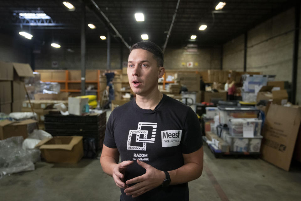 Andriy Boychuk, an organizer with Razom for Ukraine, a New York-based nonprofit, is interviewed as colleagues pack firefighting and medical donations for shipment to Ukraine, Wednesday, Feb. 8, 2023, in Woodbridge Township, N.J. (AP Photo/John Minchillo)