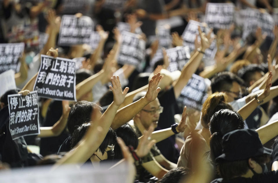 Residents of Tsuen Wan gather at an open air stadium to protest a teenage demonstrator shot at close range in the chest by a police officer in Hong Kong, Wednesday, Oct. 2, 2019. Hong Kong office workers and schoolmates of the teenage demonstrator rallied Wednesday to condemn police tactics and demand accountability. (AP Photo/Vincent Thian)