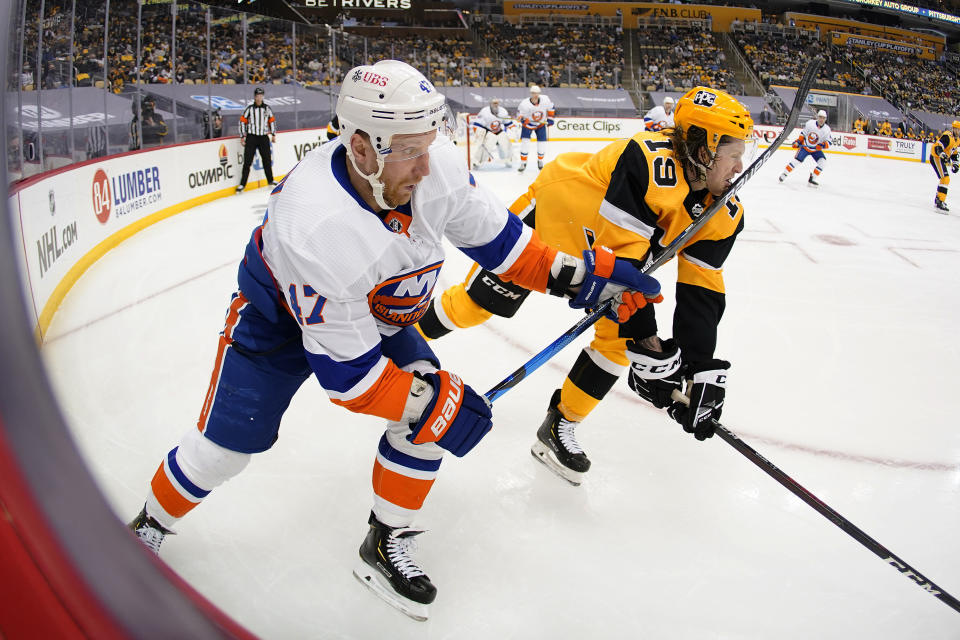 New York Islanders' Leo Komarov (47) follows through on a pass and hits Pittsburgh Penguins' Jared McCann (19) in the face during the second period in Game 2 of an NHL hockey Stanley Cup first-round playoff series in Pittsburgh, Tuesday, May 18, 2021. (AP Photo/Gene J. Puskar)
