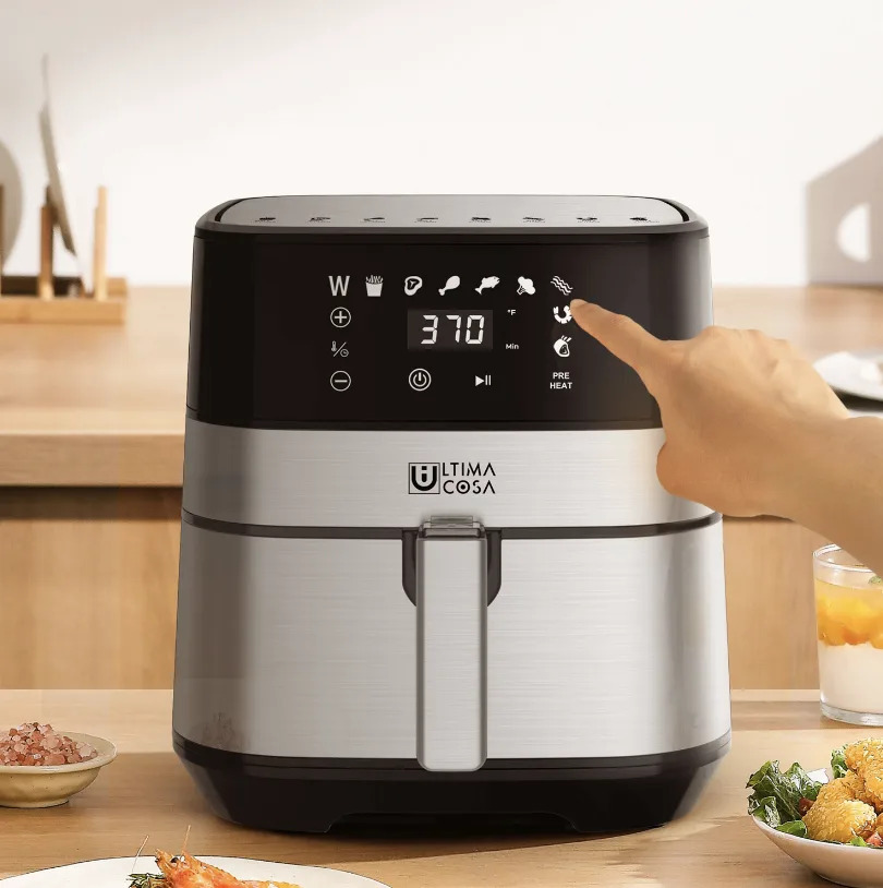 hand touching Ultima Cosa Digital Air Fryer on kitchen countertop (Photo via Best Buy)