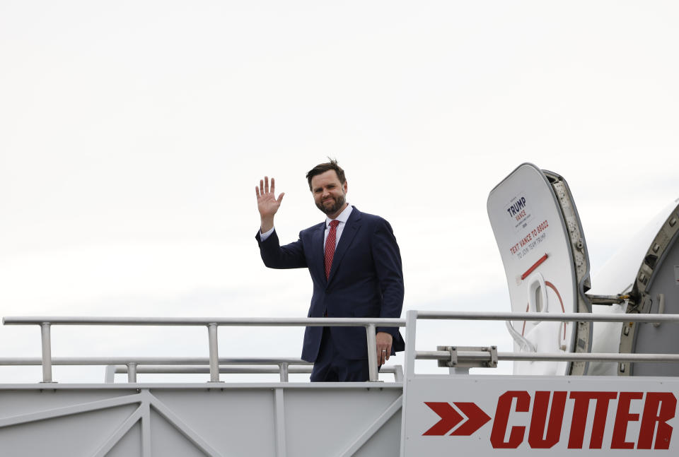 J.D. Vance waves while boarding a plane from the Cutter Aviation terminal