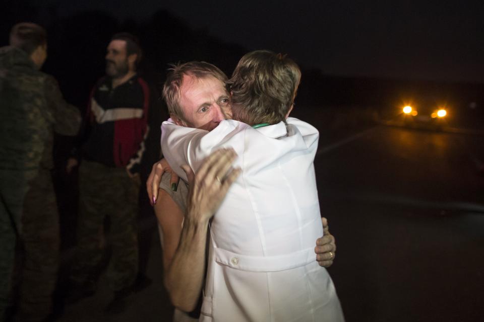 A member of the pro-Russian rebels who had been a POW hugs a friend after being exchanged, north of Donetsk, eastern Ukraine