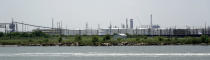 Storage tanks at a refinery along the waterway are shown Thursday, July 26, 2018, in Port Arthur, Texas. The oil industry wants the government to help protect some of its facilities on the Texas Gulf Coast against the effects of global warming. One proposal involves building a nearly 60-mile “spine” of flood barriers to shield refineries and chemical plants. Many Republicans argue that such projects should be a national priority. But others question whether taxpayers should have to protect refineries in a state where top politicians still dispute whether climate change is real. (AP Photo/David J. Phillip)