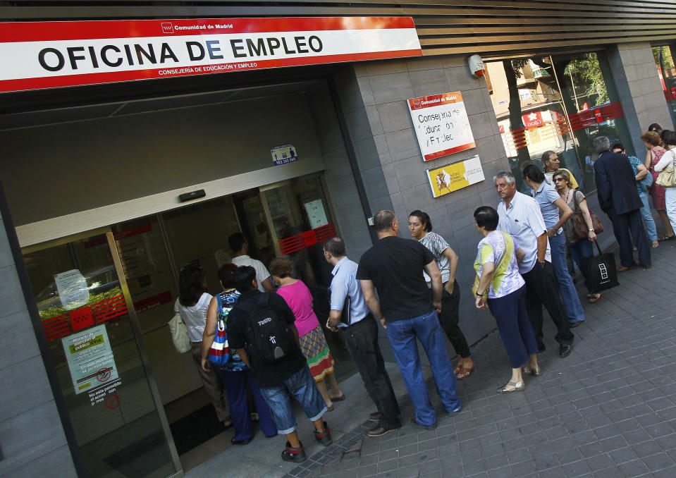 People queue outside an unemployment office in Madrid, Spain, Tuesday, July 3, 2012. The number of people claiming unemployment benefits in Spain went down sharply in June as employers embarked on a hiring spree to prepare for the country's busy summer tourism season. Spain's jobless rate is 52 percent for those under age 25. (AP Photo/Andres Kudacki)