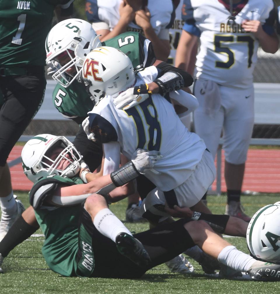 After hauling in a pass, Oakfield-Alabama/Elba's Jack Cianfrini gets brought down by Avon's Wesley Farley and Jordan Murray (5) in the second half.