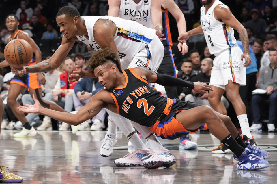 New York Knicks guard Miles McBride (2) fights for a loose ball against Brooklyn Nets center Nic Claxton during the first half of an NBA basketball game, Saturday, Jan. 28, 2023, in New York. (AP Photo/Mary Altaffer)