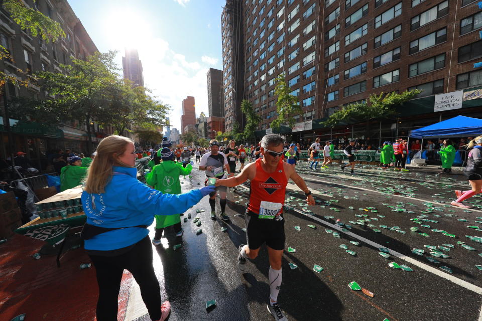 Runners are handed cups of water by volunteers on First Avenue during the 2019 TCS New York City Marathon, Nov. 3, 2019 in New York City. (Photo: Gordon Donovan/Yahoo News) 