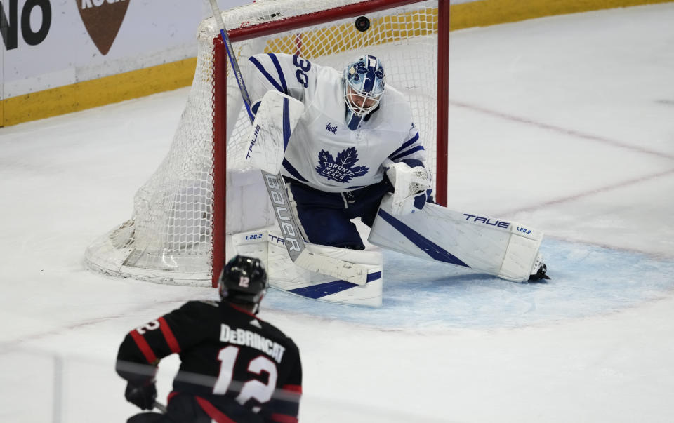 The puck beats Toronto Maple Leafs goaltender Matt Murray, top, on a shot from Ottawa Senators right wing Alex DeBrincat, bottom, during third-period NHL hockey game action in Ottawa, Ontario, Saturday, March 18, 2023. The goal was disallowed after it was ruled that DeBrincat was offside on the play. (Adrian Wyld/The Canadian Press via AP)