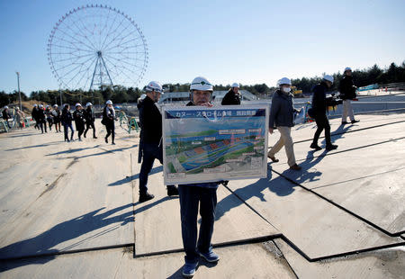 A man holds a conceptional drawing at the construction site of the Kasai Canoe Slalom Centre for Tokyo 2020 Olympic games in Tokyo, Japan February 12, 2019. REUTERS/Issei Kato